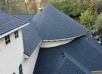 Conical turret roof finished in dark architectural shingles by DG Contracting
