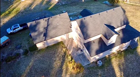 Aerial view of a new GAF Timberline shingle roof over a home and garage, by DG Contracting