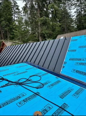 Metal roof panels installed over synthetic underlayment by DG Contracting